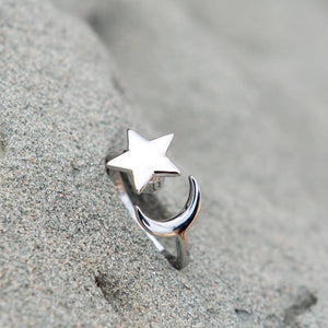 Moon and star ring on a grey stone close up