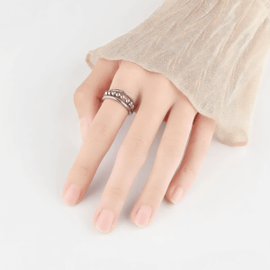 Woman's hand wearing a silver calming ring on a white counter top