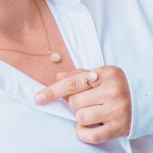 Woman in white shirt wearing anxiety jewellery set ring and necklace with opal spinning top