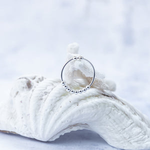 Anxiety ring with beads made of sterling silver hung on a coral