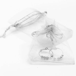 Sterling silver adjustable ring in organza pouch on white background