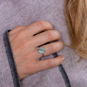 Woman wearing a planet anxiety ring that spins in silver on grey shawl background