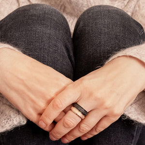 Woman's hands wearing black and rose gold sparkly worry rings