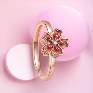 Adjustable fidget ring with flower spinning top on pink background