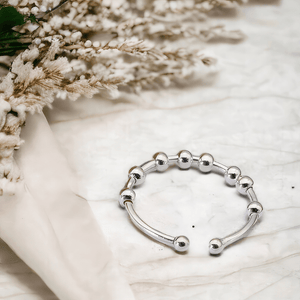 Adjustable ring on a marble counter top next to white flowers