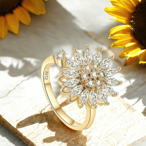Adjustable sunflower ring on a cream stone next to sunflowers