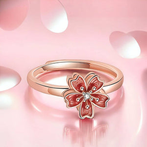 Anxiety ring with sakura flower spinning top rose gold on pink background