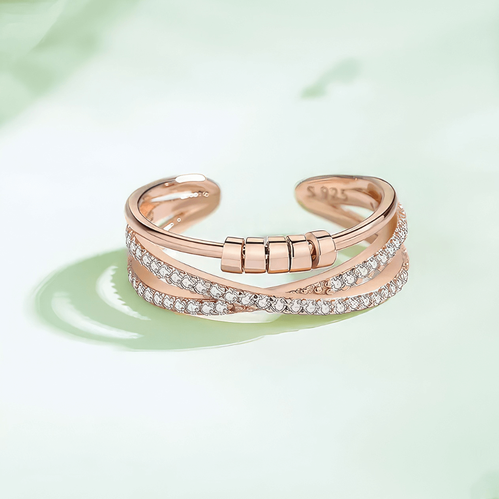 Cubic Zirconia Cross Over worry Ring rose gold on a green surface