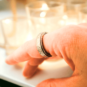 Damascus ring on a woman's index finger with candles in background
