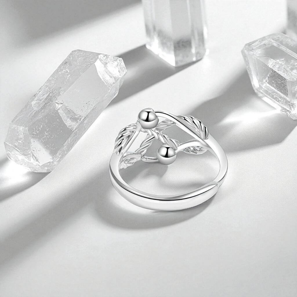 Fidget ring sterling silver with to beads on a grey surface and quartz crystals in background