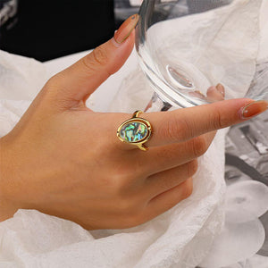 Gold abalone rotating ring on a woman's hand