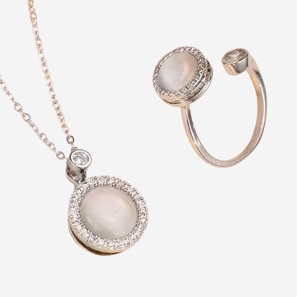 Jewelry set with a necklace and ring featuring round gemstones and rose gold accents on a white background.