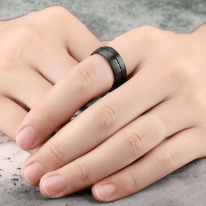 Man's hands wearing a black titanium ring  close up
