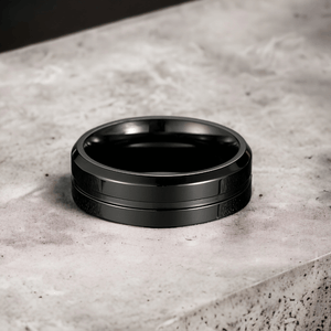 Mens black titanium ring on a grey stone counter top