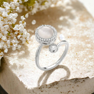 Opal fidget ring silver on a cream marble surface next to white flowers