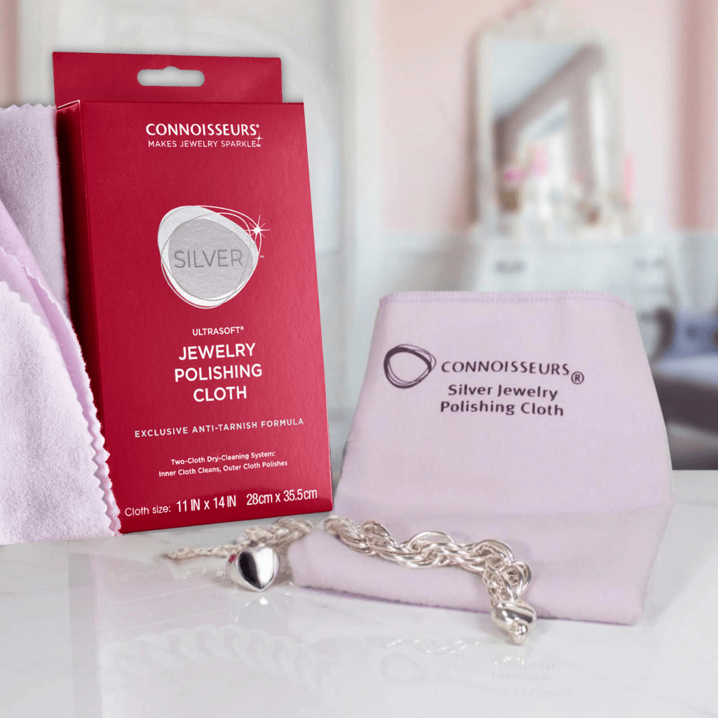 Silver bracelet and UltraSoft silver jewellery polishing cloth by Connoisseurs on a white surface