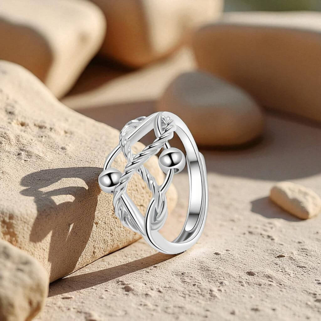 Silver fidget ring with a decorative design on a stone surface