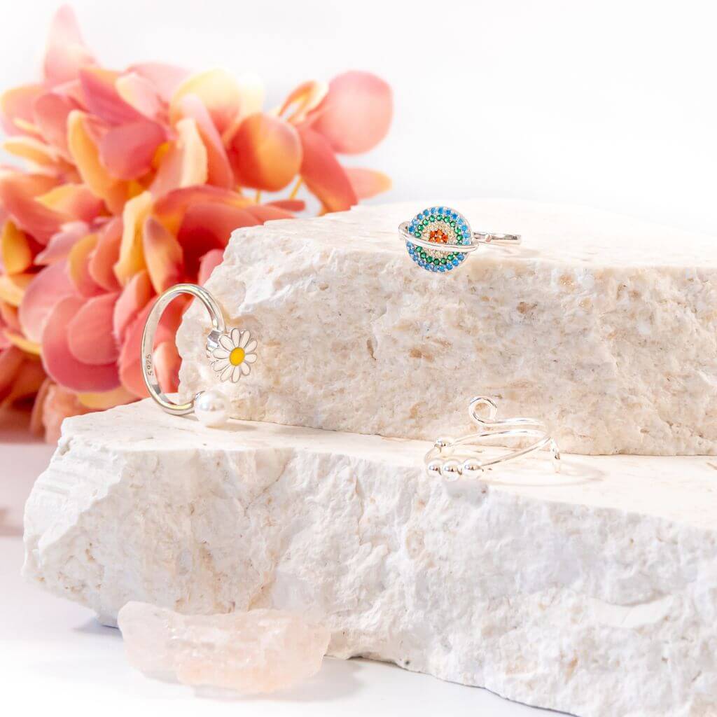 Soothing bundle of 3 women's spinner rings on a white stone close up