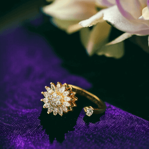 Sunflower fidget spinner ring on purple velvet next to rose petals