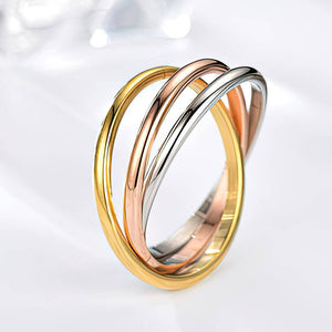 Three interlocking rings in gold, rose gold, and silver on a light gray background