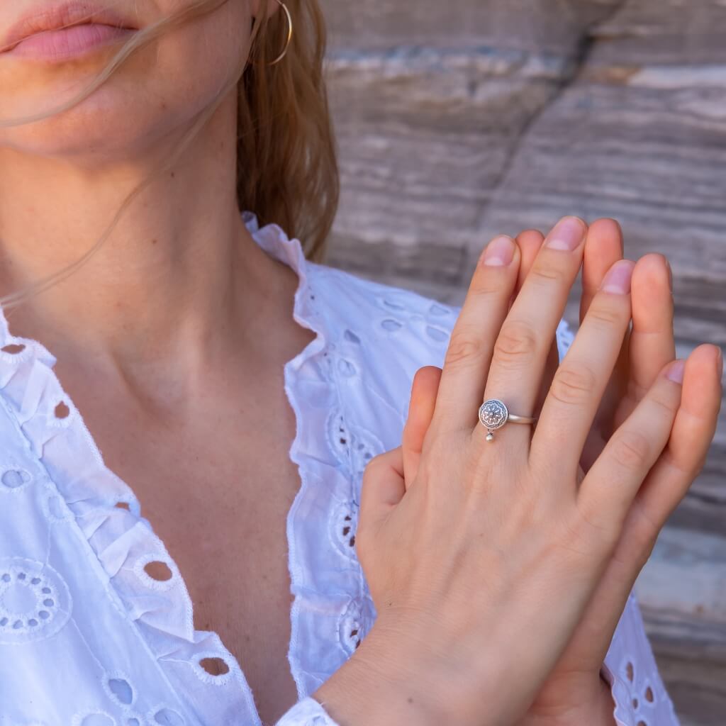 Tibetan prayer wheel anxiety fidget ring on a woman's hand in prayer