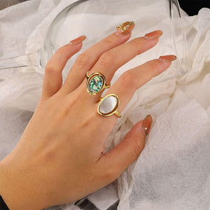 Two gold abalone rings on a woman's hand