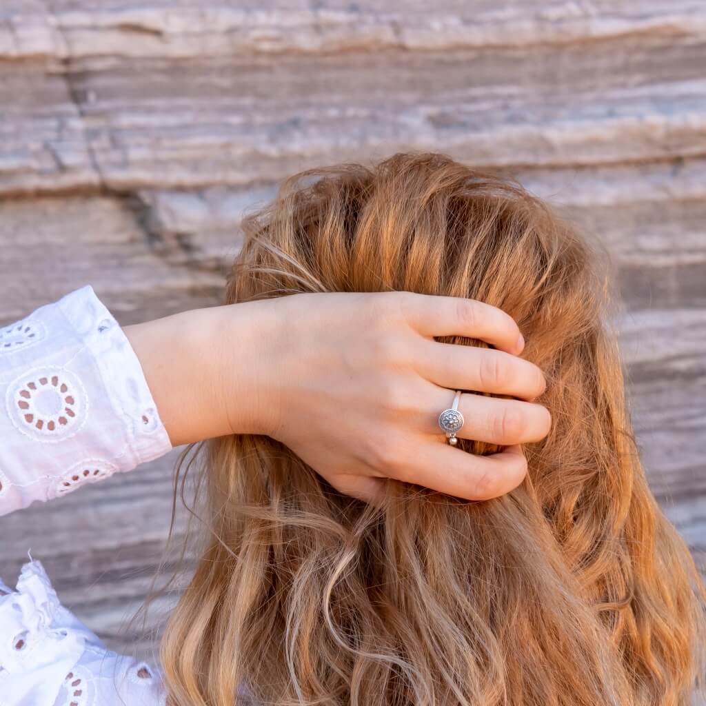 Woman holding hair with a hand wearing a spinning ring made of sterling silver