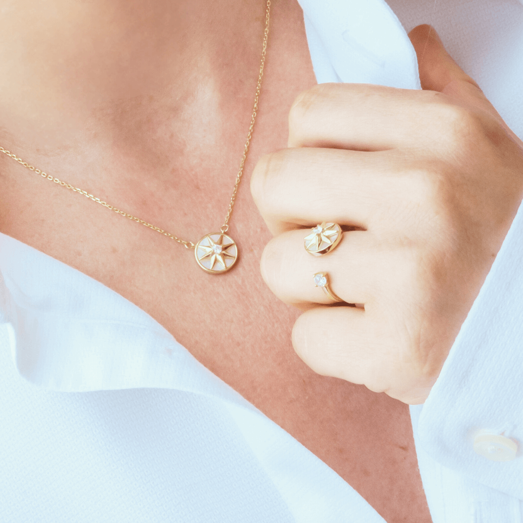 Woman in white shirt wearing anxiety jewellery set necklace and ring with a spinning top