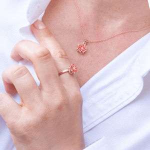 Woman in white shirt wearing an anxiety jewellery set ring and necklace with cherry blossom top 