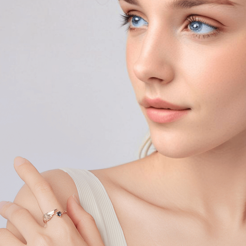 Angel wing heart ring worn by model featuring wing design and heart shaped gemstone