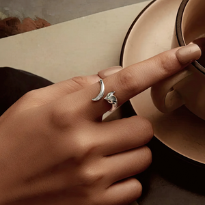 Adjustable sterling silver fox anxiety ring worn on hand holding cup