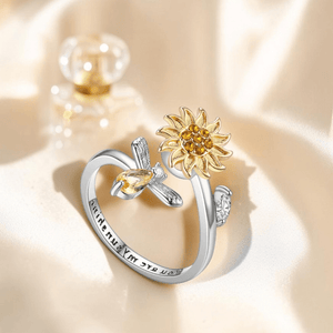 Two-tone sunflower bee fidget ring showing you are my sunshine engraving inside band on cream silk with perfume bottle