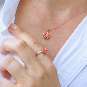 Woman in white shirt wearing a fidget necklace and ring with flower top
