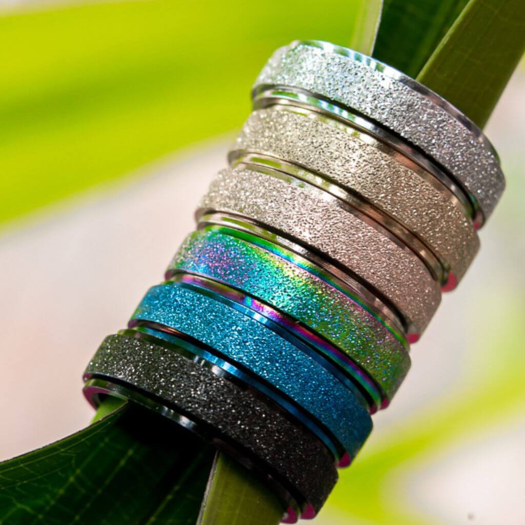 6 sparkly worry rings on a green leaf