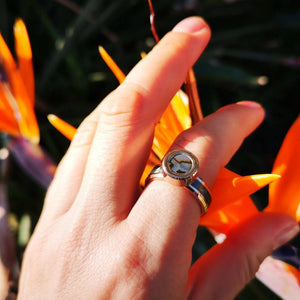 Abalone ring on woman's hand orange flower background