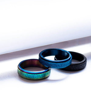 Black, blue and rainbow sparkly worry rings on white background