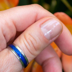 Colour changing ring blue on a thumb close up