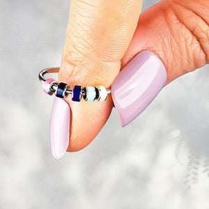 Colorful fidget ring with beads on a woman's finger close up