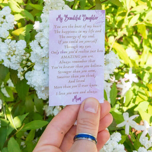 Hand wearing a mood ring colour blue holding a message card