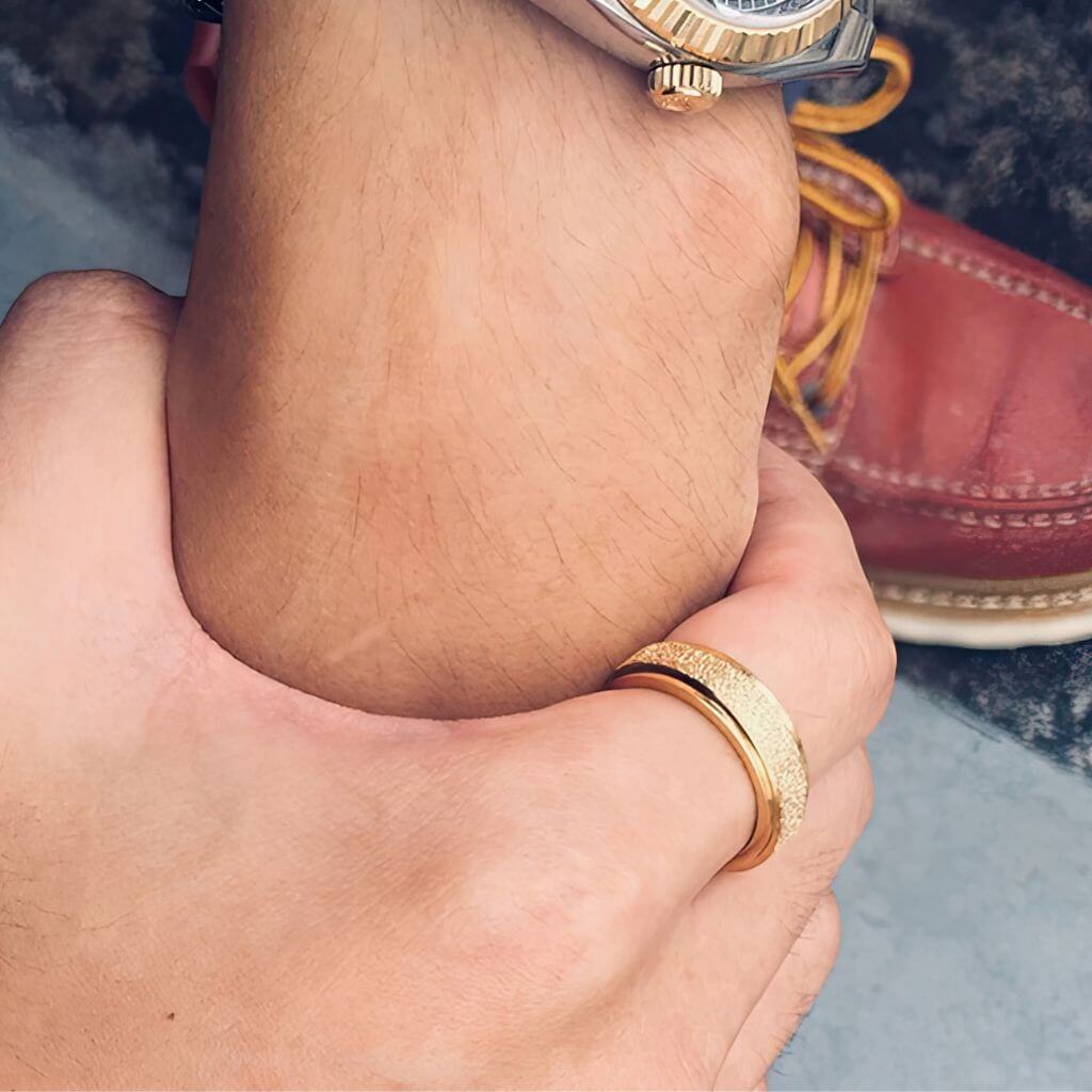 Man wearing a gold sparkly worry ring