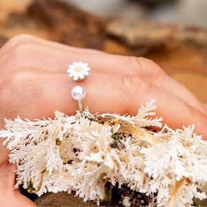 Pearl ring with flower on a woman's hand close up
