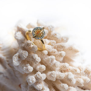Planet anxiety ring for women in gold on a white coral