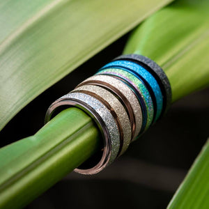 Spinner rings on a green leaf silver, gold, rose gold, rainbow, blue, black