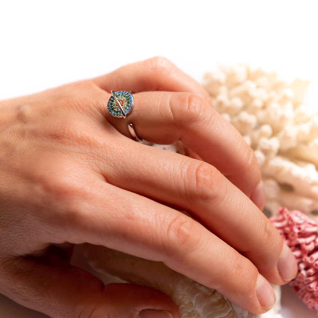 Woman wearing a planet adjustable anxiety in silver next to a white coral