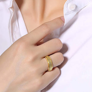 Woman's hand wearing a gold spinner ring on white background